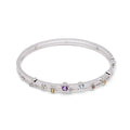 A silver-toned hinged bangle bracelet featuring a row of small, round, multicolored gemstones set along the front, displayed on a clean white background.