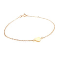 Gold bracelet with a heart-shaped charm on a white background